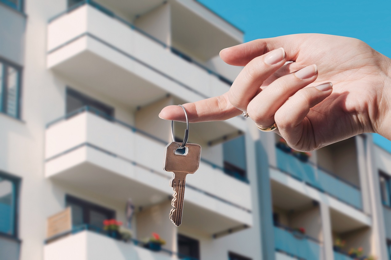 Kobieta trzyma w dłoni klucze do swjego nowego mieszkania