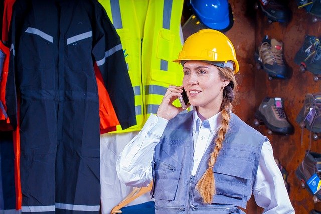 Kobieta pracujaca na budowie dzwoni do hurtowni odieży roboczej