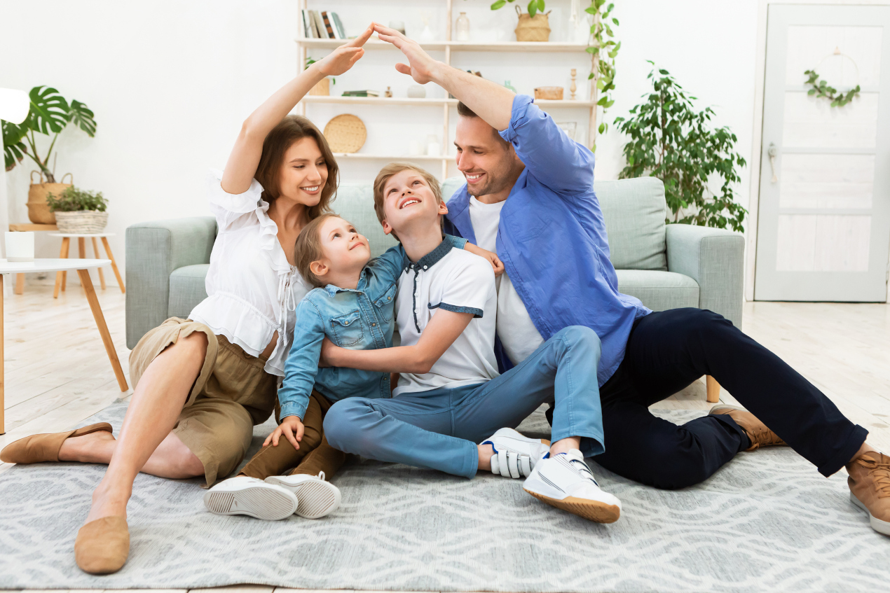 Rodzice z dziećmi siedzą na podłodze swojego mieszkania
