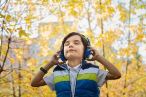 Chłopiec słucha audiobooka na słuchawkach