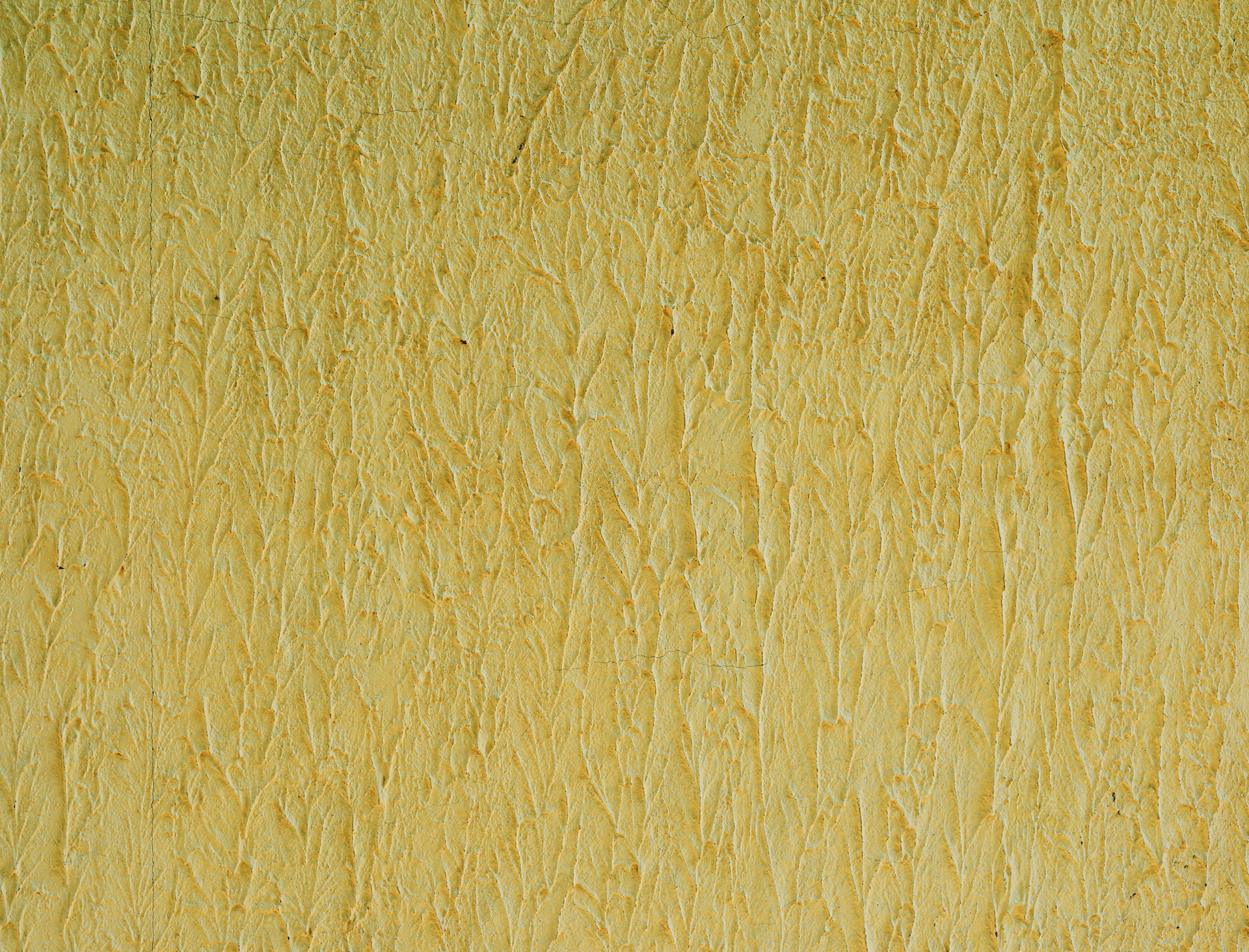 Na obrazku widzimy żółtą ścianę, która ma ciekawą strukturę. Widać, że struktura została stworzona poprzez zastosowanie nierówności i faktur na powierzchni ściany. Dzięki temu ściana nabiera charakteru i wyjątkowego stylu. Kolor żółty dodaje wnętrzu energii i pozytywnej atmosfery. Obrazek ten może kojarzyć się z nowoczesnością, kreatywnością i designem, a także z oryginalnym i odważnym podejściem do aranżacji wnętrz.