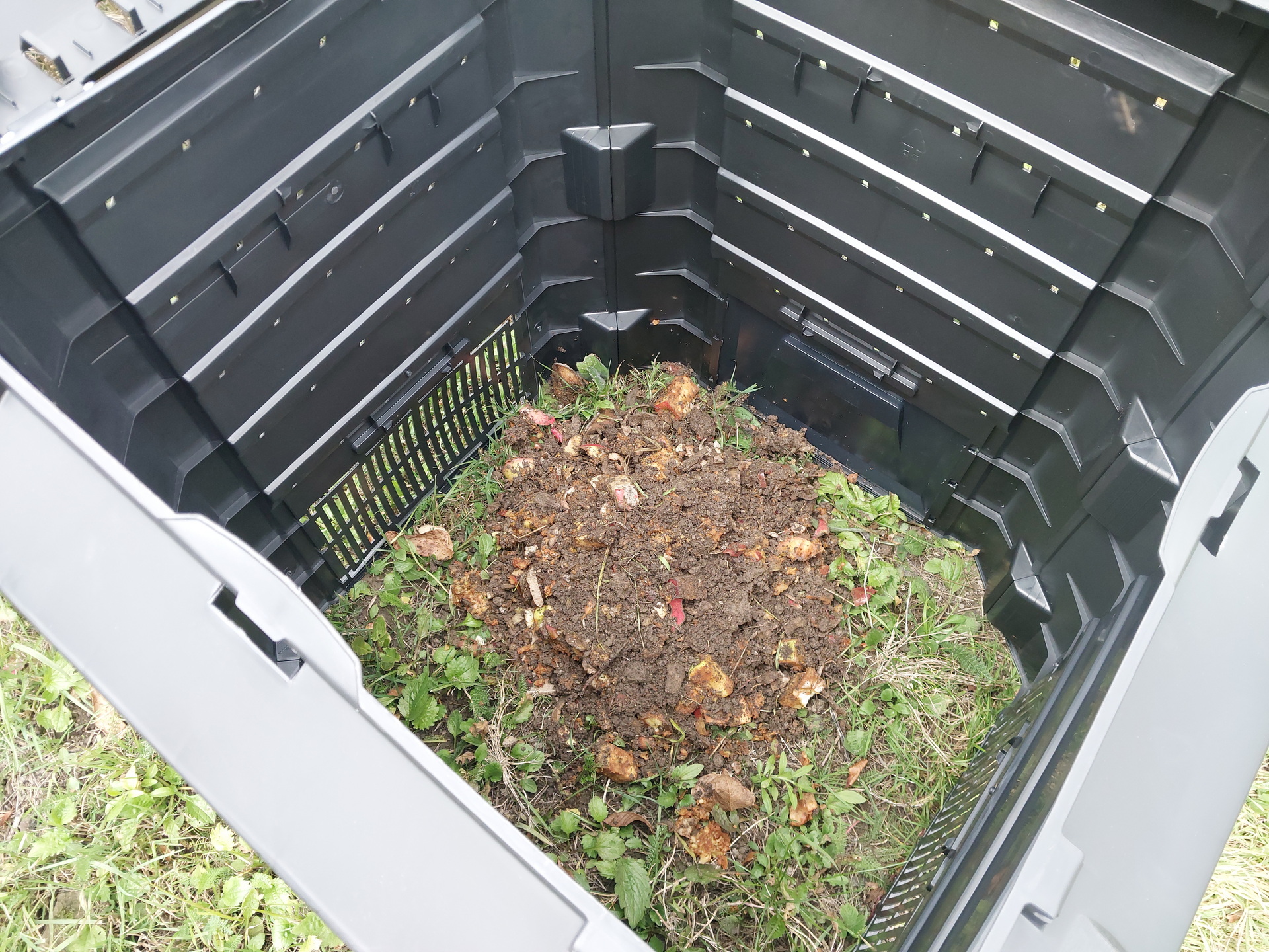 Na tym obrazku widzimy górkę kompostu z trawy, która jest gotowa do wykorzystania. Kompost jest ciemnobrązowy i dobrze rozłożony, co świadczy o skutecznym procesie rozkładu organicznej trawy. Ta wartościowa substancja organiczna może być wykorzystana jako naturalny nawóz w ogrodzie, dostarczając składników odżywczych roślinom i wspierając zdrowy wzrost